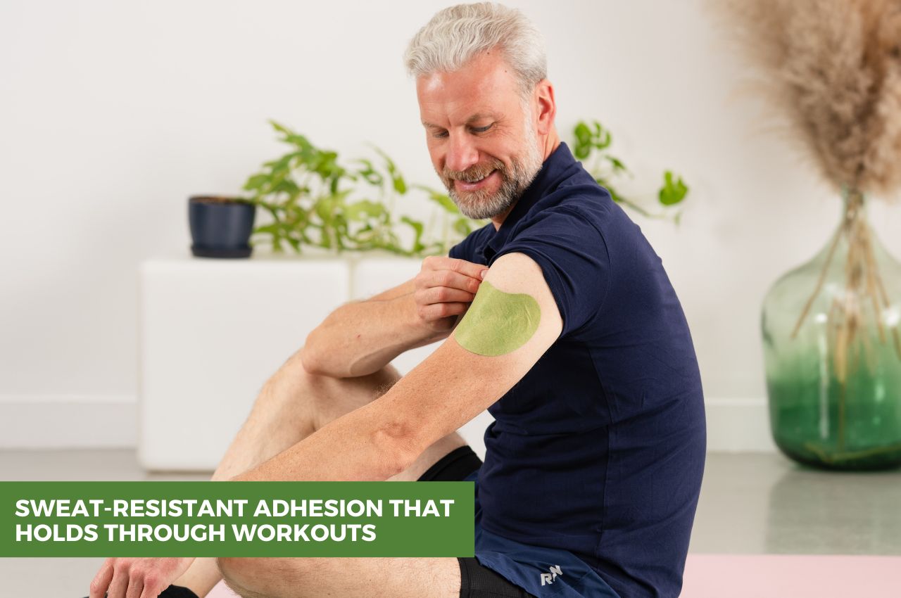Man sitting and applying FlexiShoulder patch to his shoulder